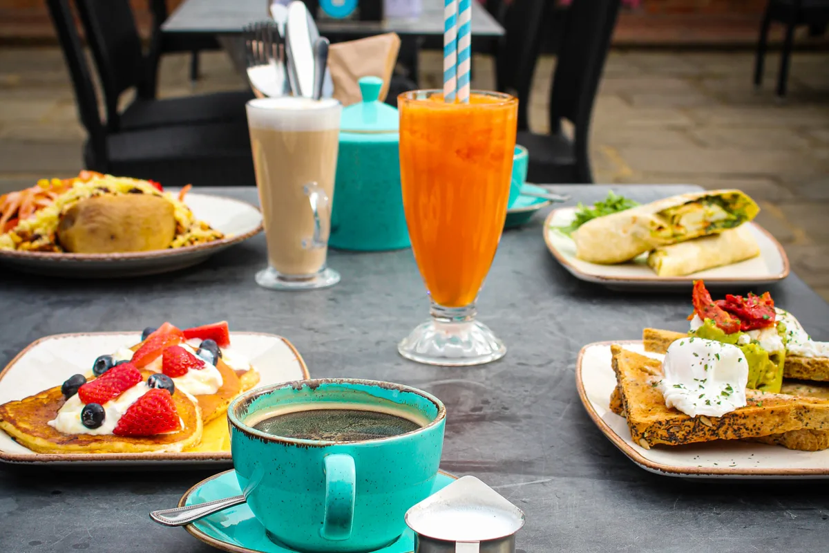 Full English breakfast and a flat white coffee at a café table in Henley-on-Thames town centre